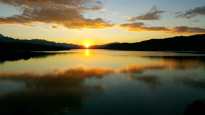 Serene Sunset Over Lake with Mountain Reflections