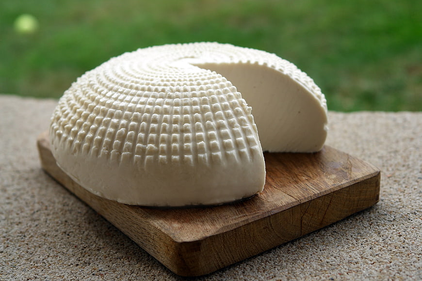 Fresh White Goat Cheese Wedge on Wooden Board
