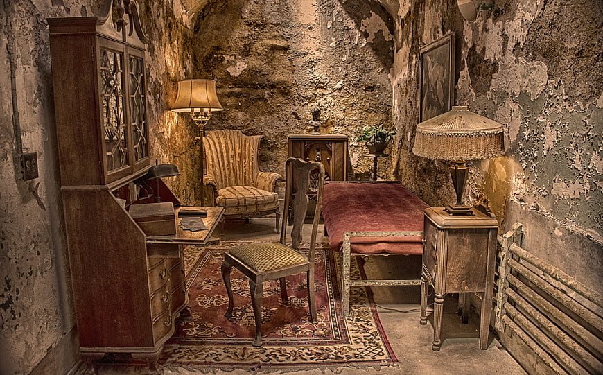 Vintage furniture in historic crumbling prison cell interior