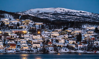 Snowy Hillside Village at Dusk by the Water