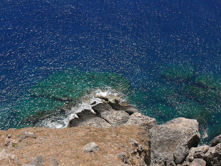 Aerial View of Rocky Coastline with Turquoise and Deep Blue Sea