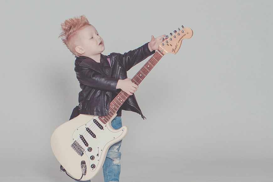 Toddler with Mohawk Playing Electric Guitar in Leather Jacket
