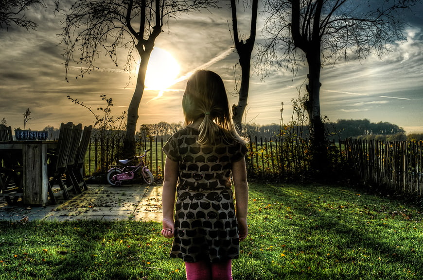 Little Girl Watching Sunset in Garden