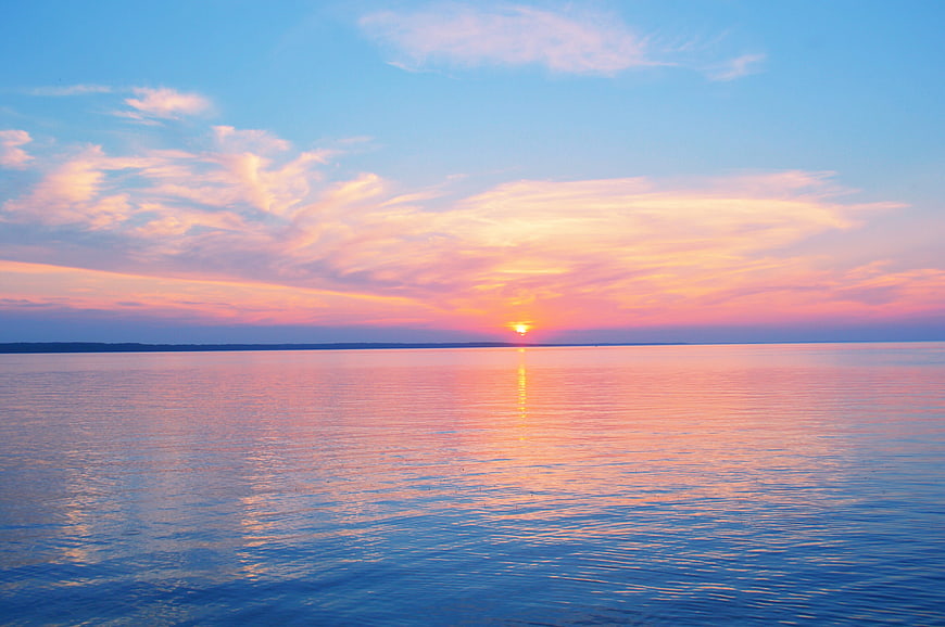 Serene Pastel Sunset Over Calm Lake Water