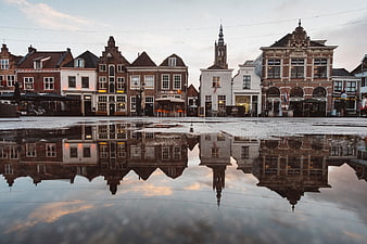 Historic Dutch town square with building reflections in water