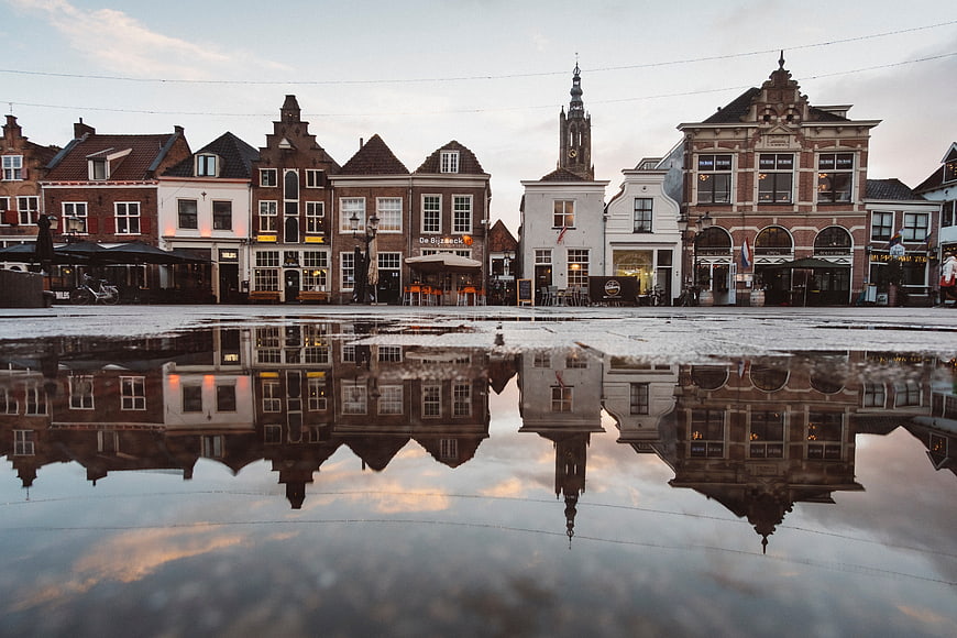Historic Dutch town square with building reflections in water