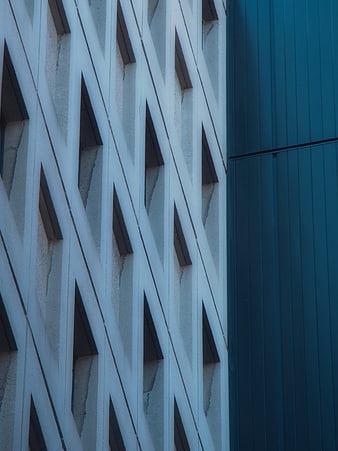 Modern building facade with geometric white lattice and blue panel