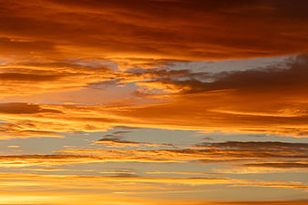 Vibrant orange sunset sky with dramatic layered clouds