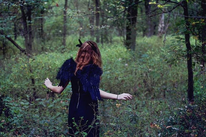 Woman with black wings in a forest
