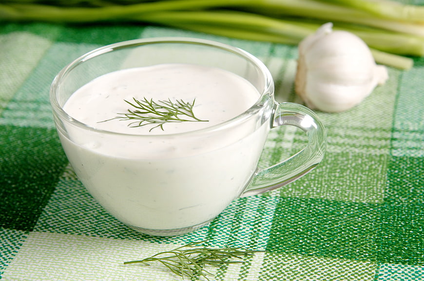 Glass Cup of Sour Cream Sauce with Dill and Garlic on Green Checkered Cloth