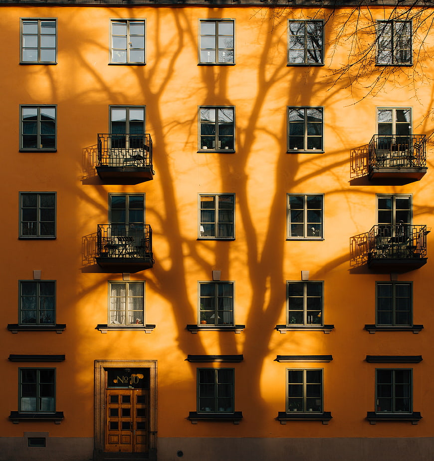Orange Apartment Building Facade with Tree Shadows