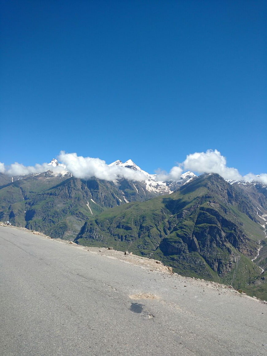 Mountain road view with snow-capped peaks and blue sky