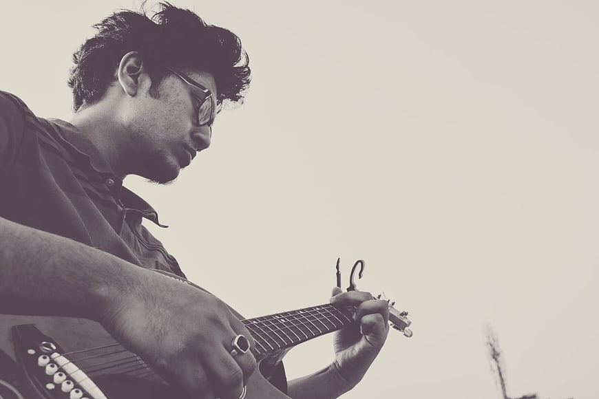 Man Playing Guitar with Sunglasses in Sepia Tone