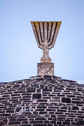 Stone Menorah Memorial on Brick Dome Against Blue Sky