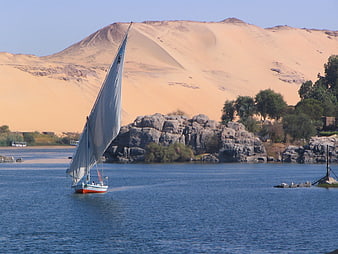 Sailboat on the Nile River with Desert Dunes and Rocks in Aswan, Egypt