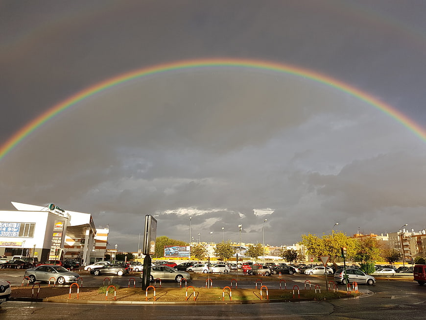 Vibrant Rainbow Arching Over Urban Parking Lot