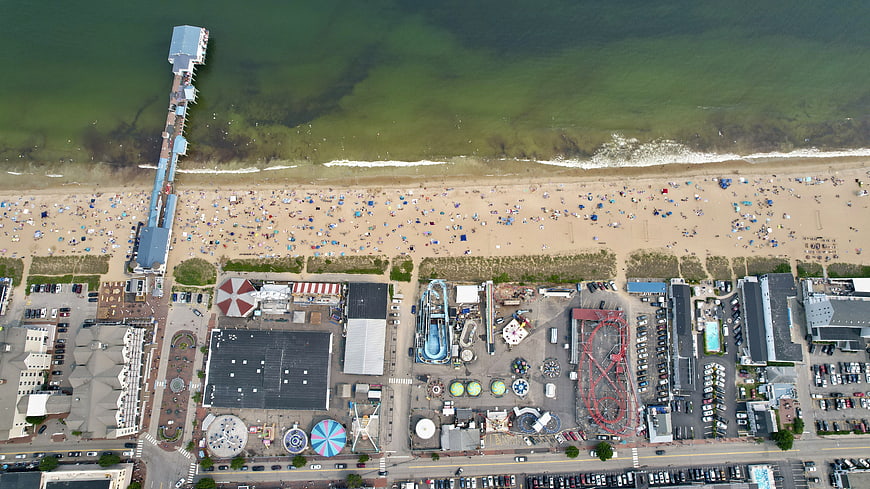 Aerial View of Busy Beach, Pier, and Amusement Park