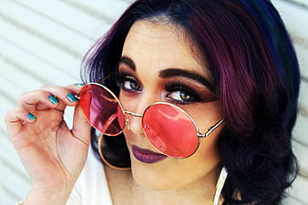Woman with purple hair and red sunglasses close-up