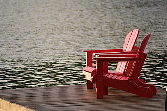 Red Adirondack Chairs on Wooden Dock by Lake