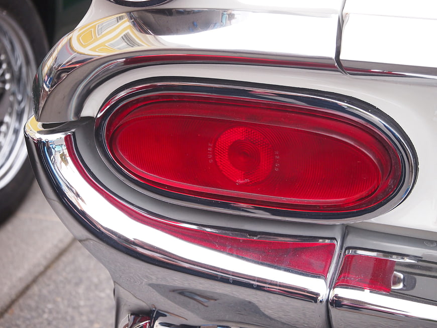 Close-up of vintage car red taillight and chrome bumper