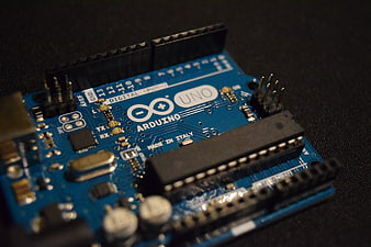 Close-up of Arduino Uno microcontroller board on dark background