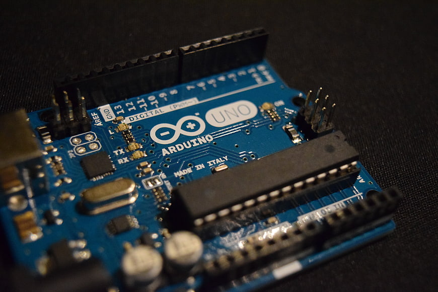 Close-up of Arduino Uno microcontroller board on dark background