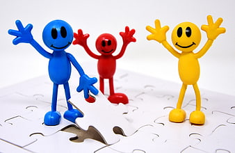 Colorful figures placing final puzzle piece teamwork concept