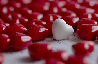 White Heart Candy Among Red Hearts on Wooden Background