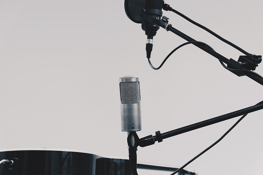 Professional Studio Microphones on Stands Against White Background