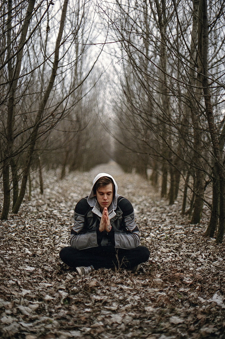 Young Man Meditating in Forest Path