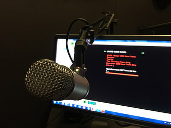 Professional broadcast microphone and computer monitor in radio studio