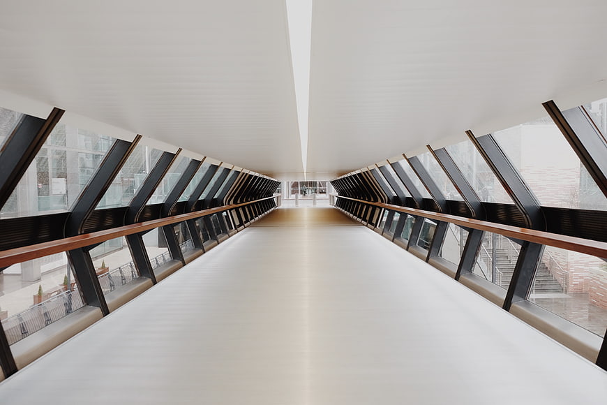 Modern architectural hallway with skylights and wooden railings