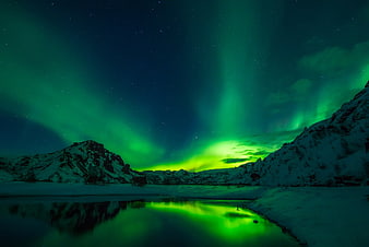Vibrant Green Aurora Borealis Reflecting in Snowy Icelandic Lake