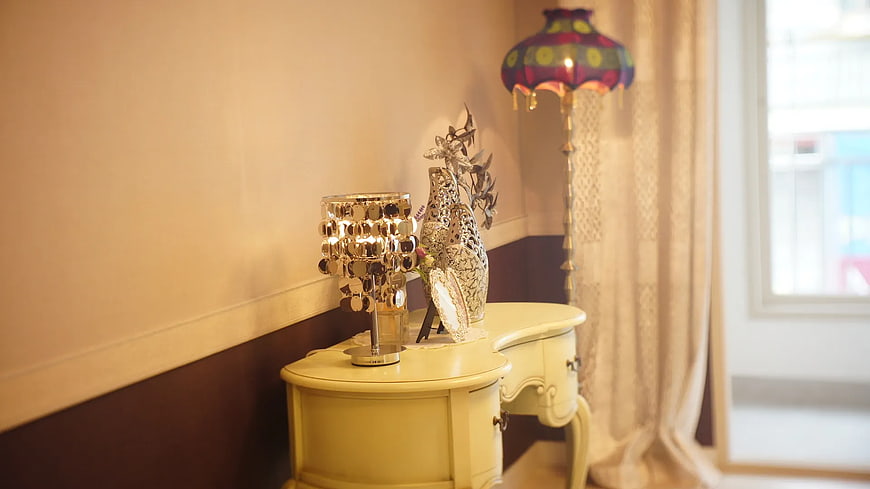 Elegant cream console table with silver decor and lamps
