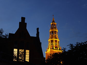 Illuminated A-kerk church tower in Groningen at blue hour