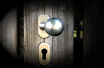 Close-up of silver door handle on weathered wooden door