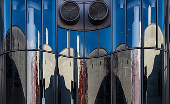 Modern glass building facade with distorted architectural reflections