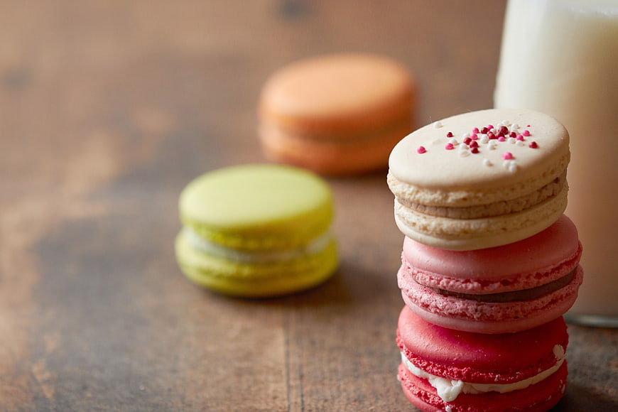 Stacked Colorful Macarons with Milk on Wooden Table
