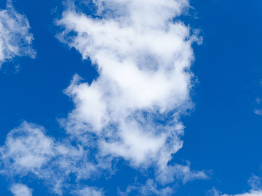 Fluffy White Clouds Against Vibrant Blue Sky Background