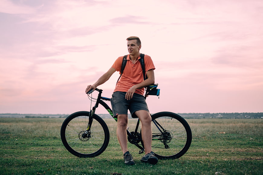 Man with Mountain Bike in Field at Sunset