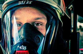 Close-up of firefighter wearing helmet and breathing apparatus