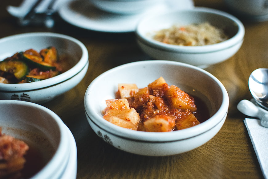 Close-up of Korean kimchi and banchan side dishes in white bowls