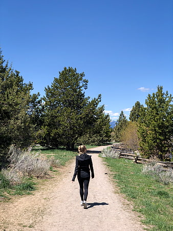 Woman Walking Away on Dirt Path in Nature