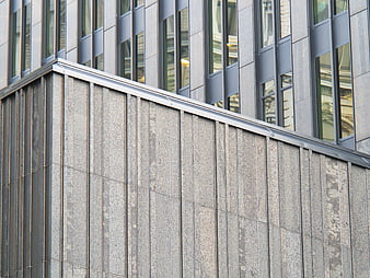 Modern gray stone building facade with glass windows