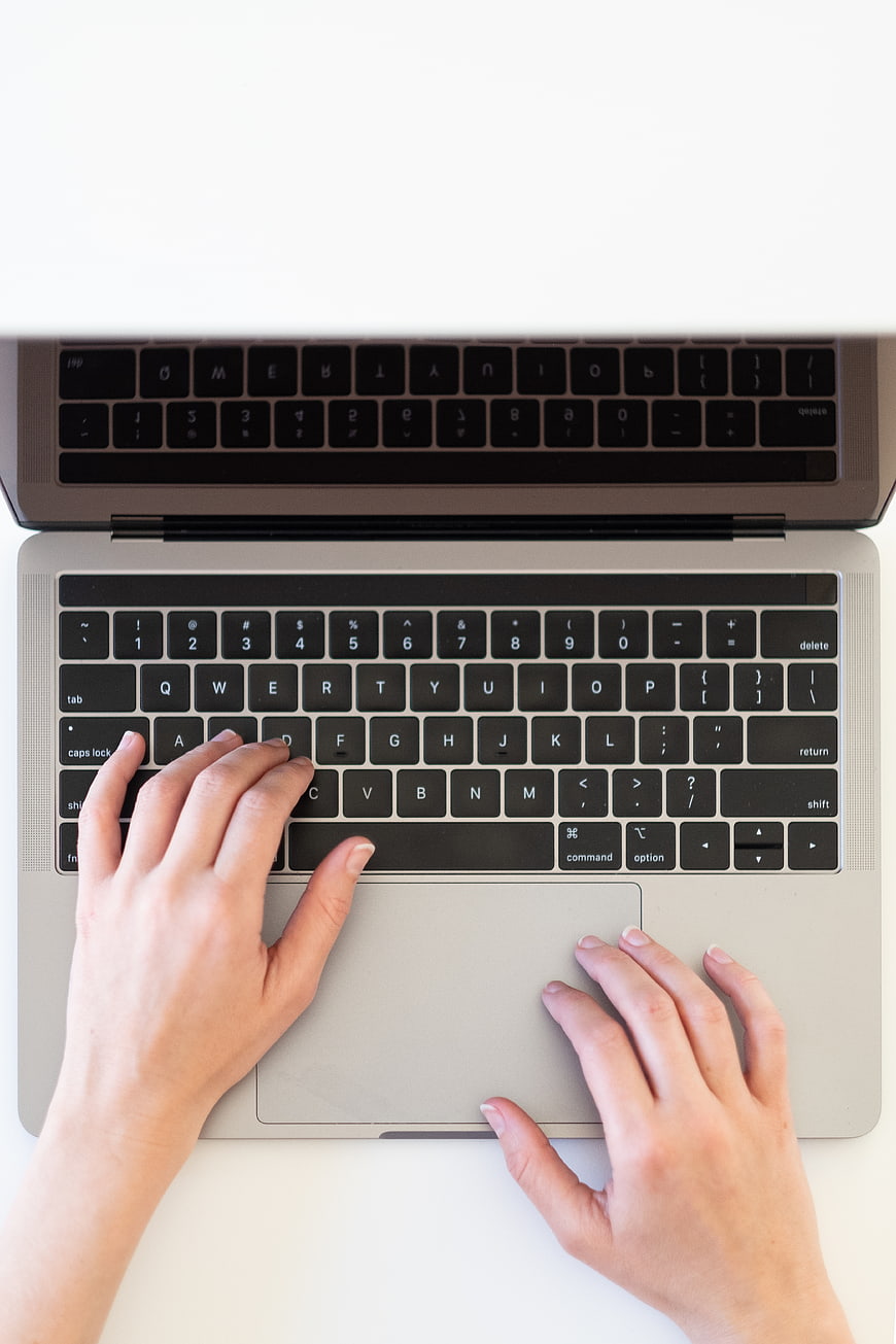 Top View of Hands Typing on Laptop Keyboard