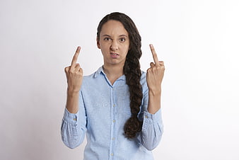 Angry woman showing middle fingers in blue shirt
