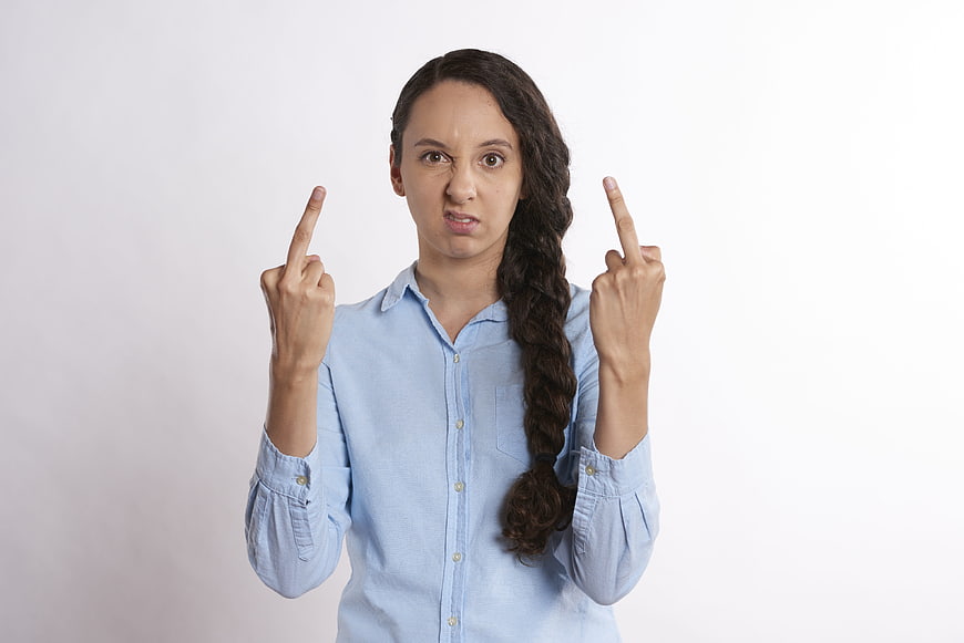 Angry woman showing middle fingers in blue shirt