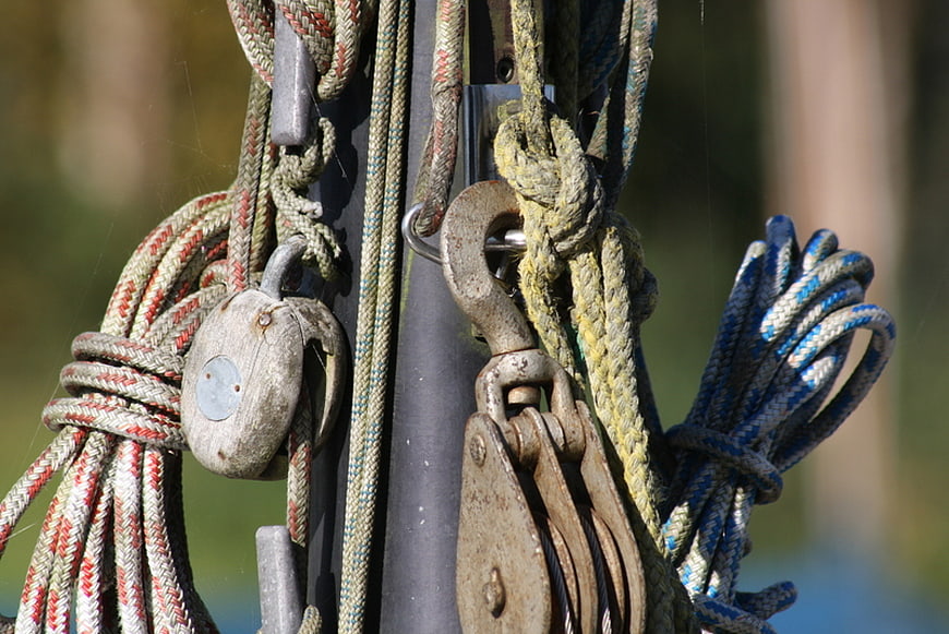 Close-up of weathered sailing ropes and pulleys on a mast