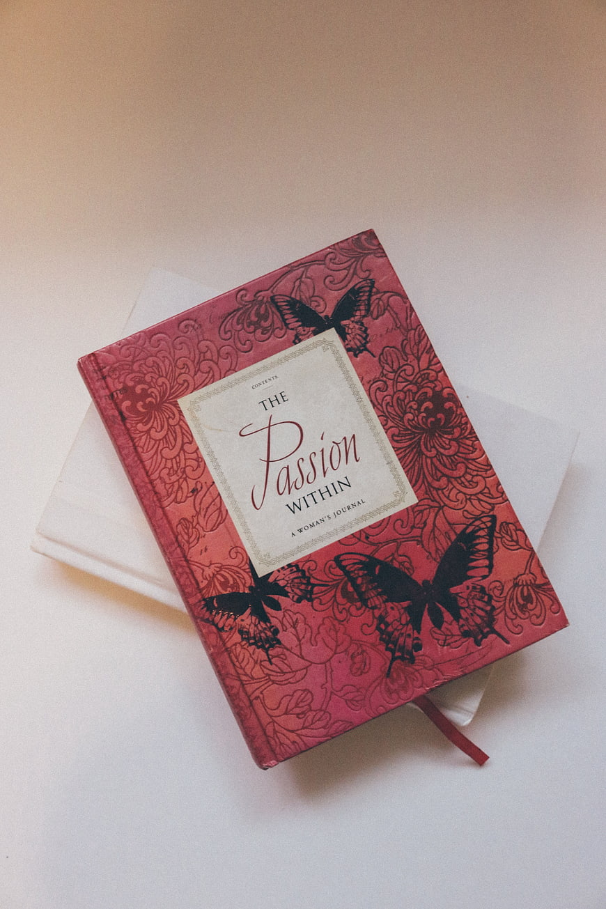 Red Journal with Butterfly Design on White Background
