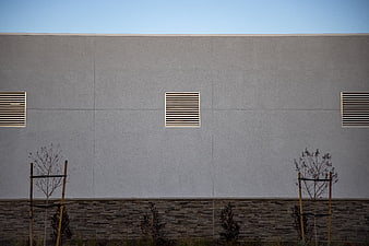 Minimalist modern building facade with gray wall and vents